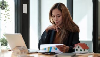 Asian business woman working for interest, taxes and profits to invest in real estate and home