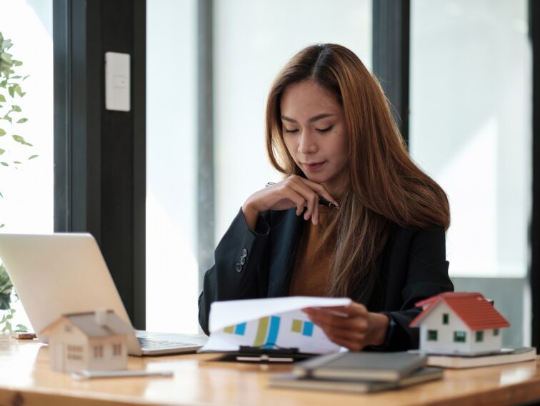 Asian business woman working for interest, taxes and profits to invest in real estate and home