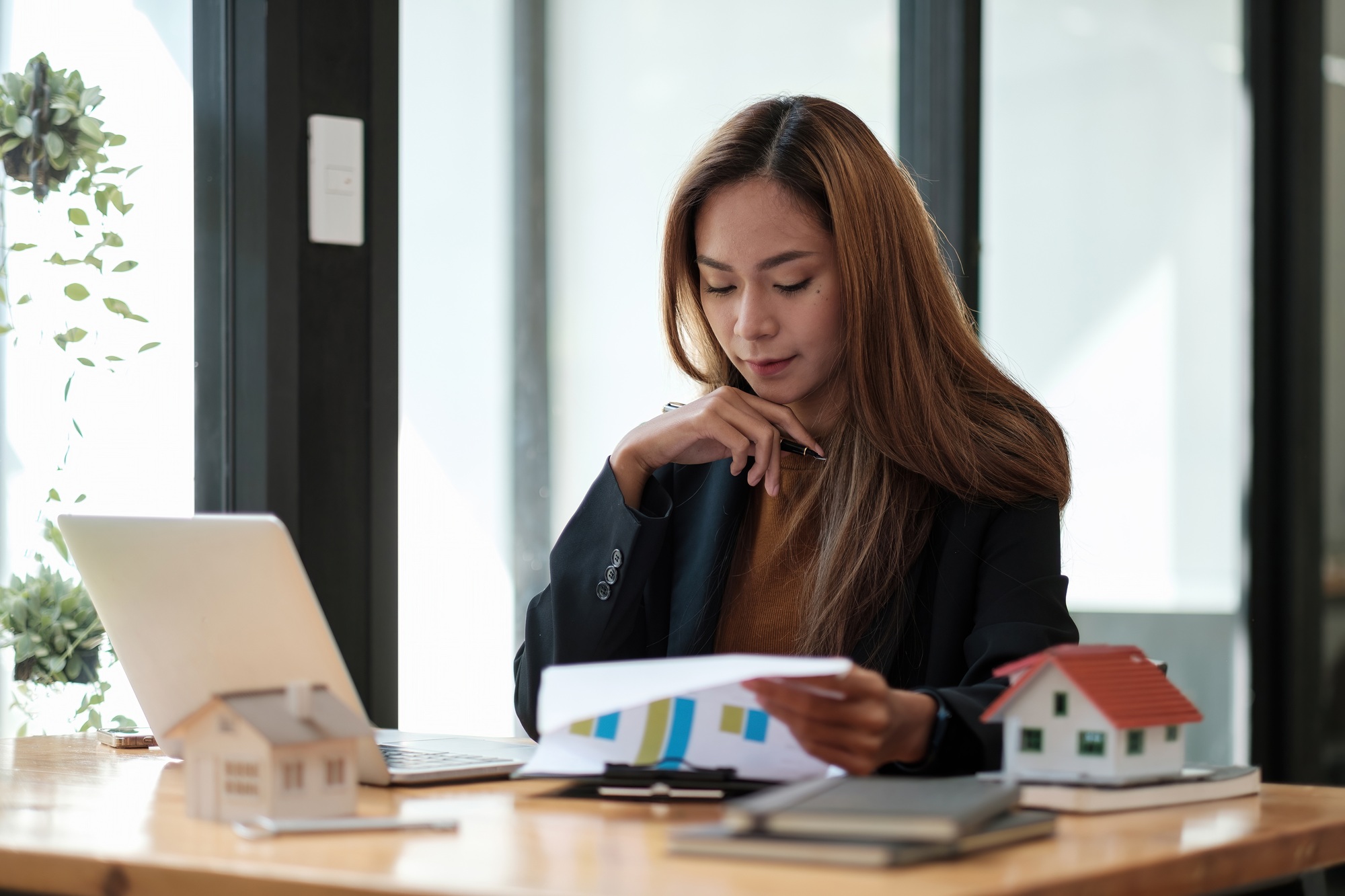 Asian business woman working for interest, taxes and profits to invest in real estate and home